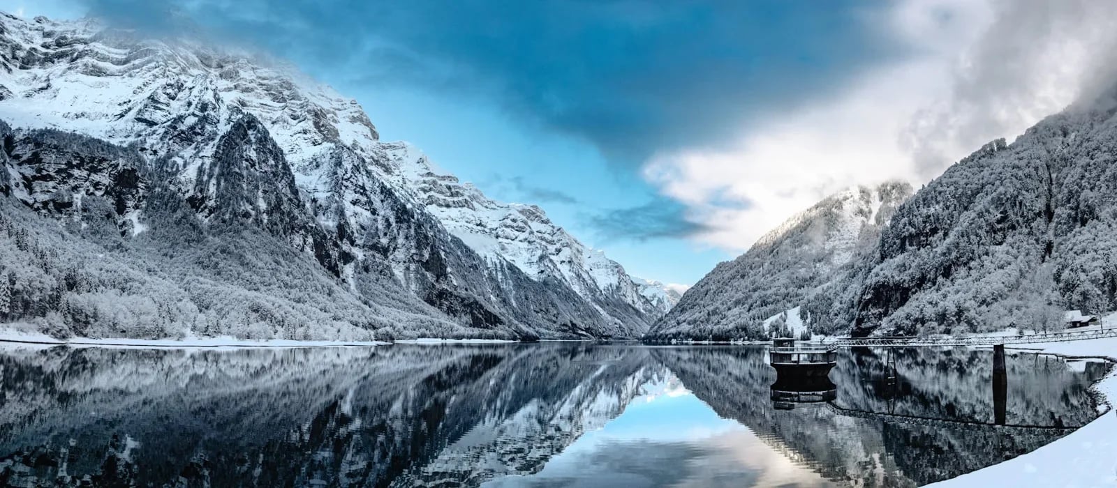 Norsk fjord med snødekte fjell, området Fiskebilen kjører i fra Kristiansand til Tromsø