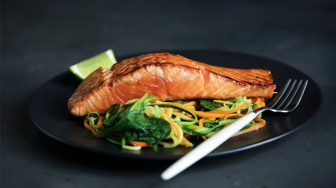 Stekt laksefilet servert på mørk tallerken, laks levert hjem av Fiskeruta